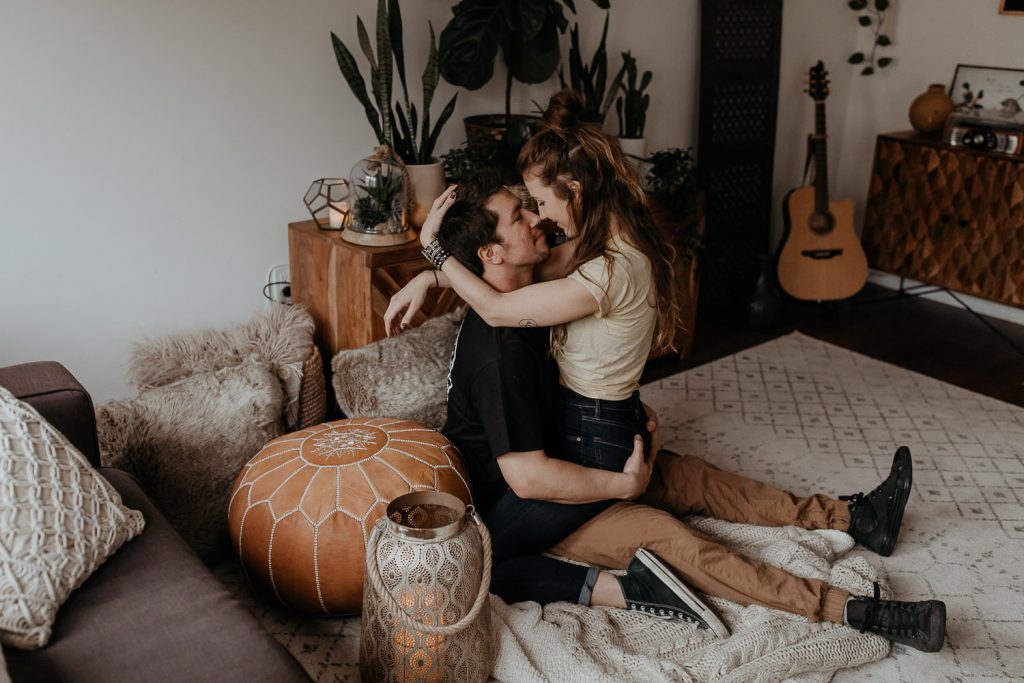 Couple cuddling in boho styled living room